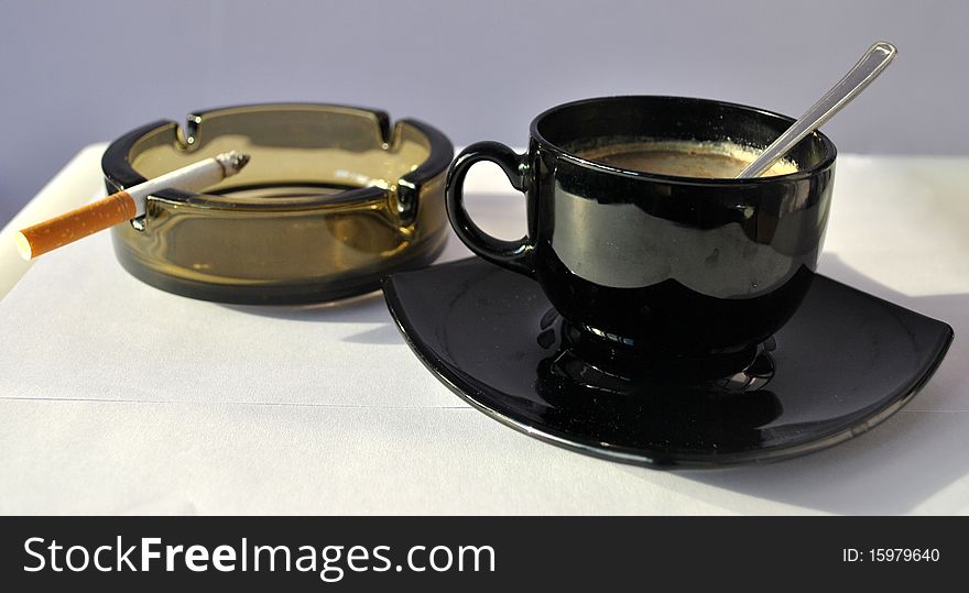 Image of a cup of coffee and a cigarette. Image of a cup of coffee and a cigarette
