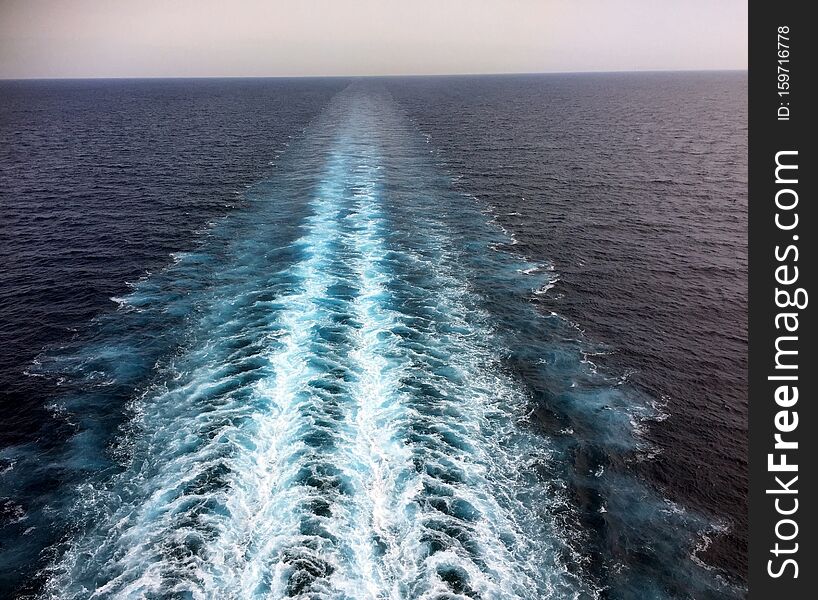 Cruise ship propeller wash on blue ocean sea
