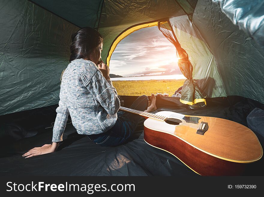 Asian Lifestyle of woman travel camping with guitar acoustic song