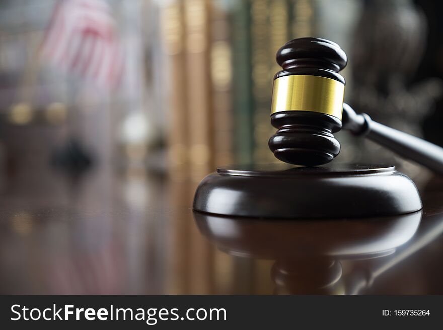 Gavel of  the judge on the wooden table and bookshelf background. Gavel of  the judge on the wooden table and bookshelf background.