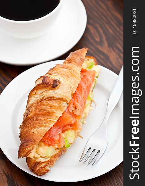 Croissant filled with smoked salmon and coffee