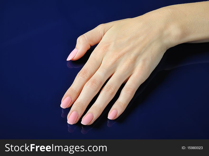 Beautiful hands with perfect nail pink manicure. isolated on blue background