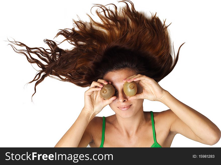 Beautiful woman lying and hold kiwi near eyes and hair is dishevelled isolated