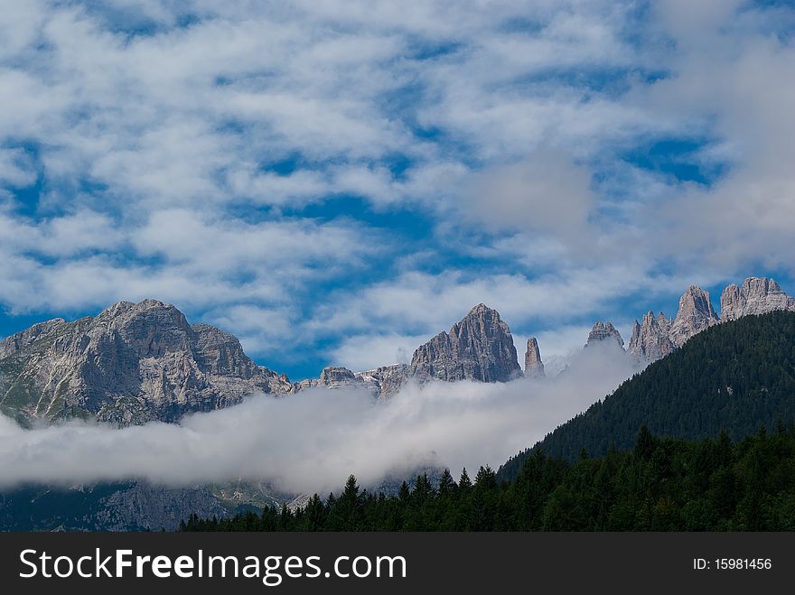 Trentino mountain scenery with mountains and clouds in a summer day