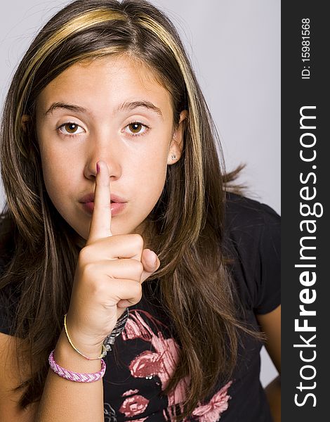 Young girl making a silence sign with her finger. Young girl making a silence sign with her finger