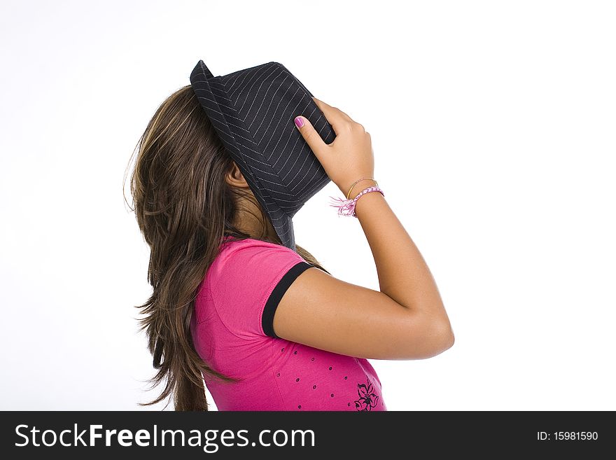 A young girl is hidding her face with a black hat. A young girl is hidding her face with a black hat