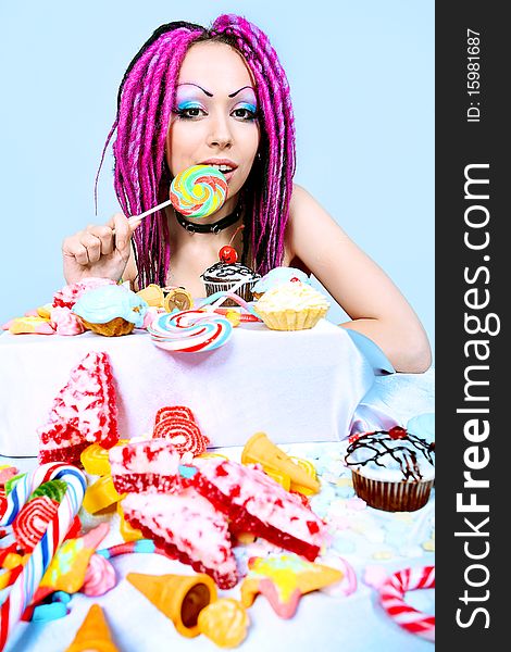 Portrait of a trendy girl with great number of sweets. Portrait of a trendy girl with great number of sweets.