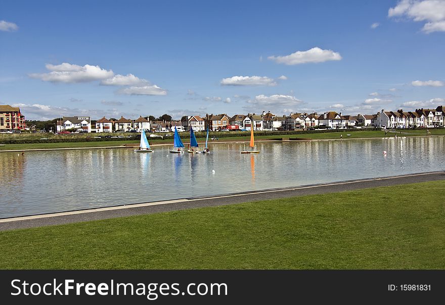 Small sailing yachts sailing on a manmade lagoon. Small sailing yachts sailing on a manmade lagoon