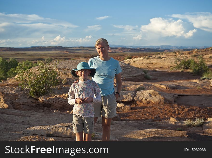 Mother and daughter pausing on a hike in the desert. Mother and daughter pausing on a hike in the desert