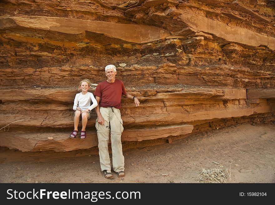 Father and daughter standing by desert rocks. Father and daughter standing by desert rocks