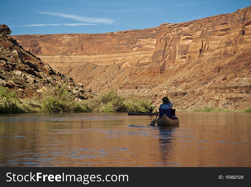 Man in a canoe on a desert river in the Utah canyon country