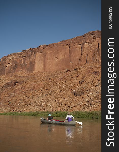 Mother and daughter canoeing on a calm blue river in the desert country of Utah. Mother and daughter canoeing on a calm blue river in the desert country of Utah