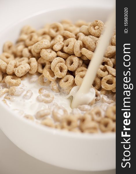Milk going over breakfast cereal, detail of bowl. Milk going over breakfast cereal, detail of bowl