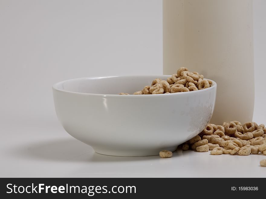 Milk in container with breakfast cereal, with extra on the side for visual texture, lower angle. Milk in container with breakfast cereal, with extra on the side for visual texture, lower angle