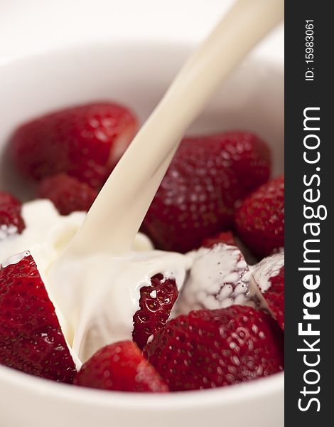 Cream going over fresh red strawberries, delicious. Cream going over fresh red strawberries, delicious