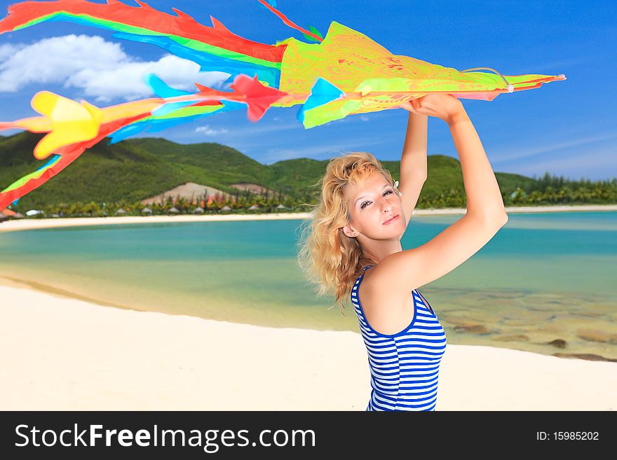 Young woman with kite on the beach
