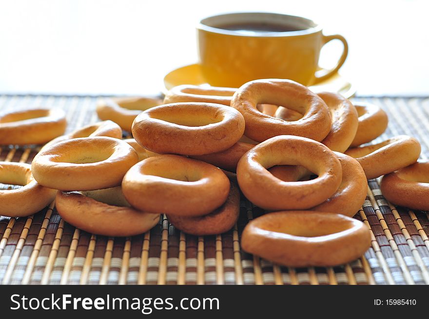 Many bagels and yellow cup of coffee. Many bagels and yellow cup of coffee