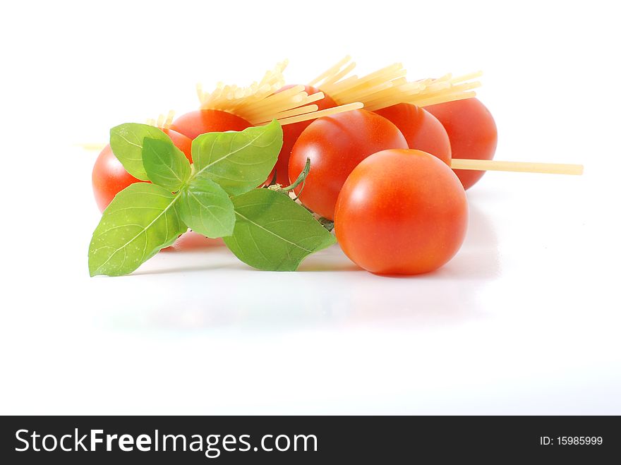 Spaghetti with tomatos and basilikum on a white background