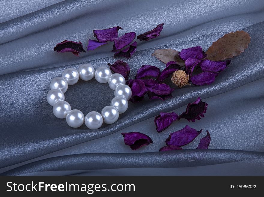 Pearl bracelet and flowers behind organza