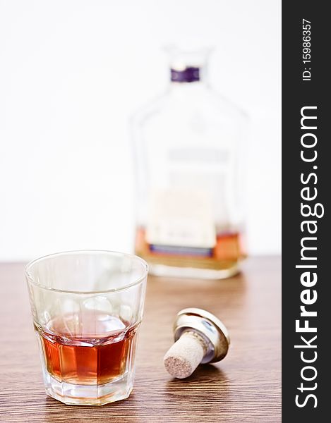 Whiskey glass and bottle on wooden counter