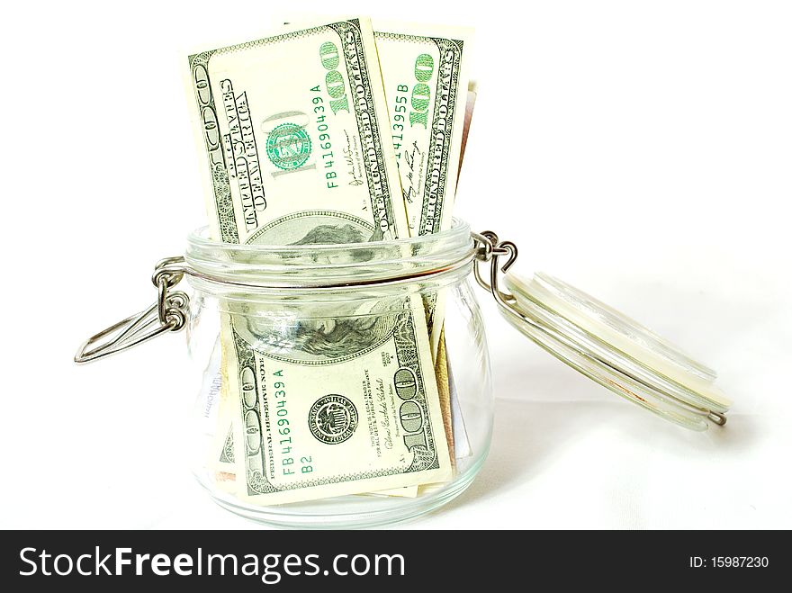 A bunch of dollars on a white background in a glass sealable bowl, keeping the money, dollar, glassware, tableware closing, finance.