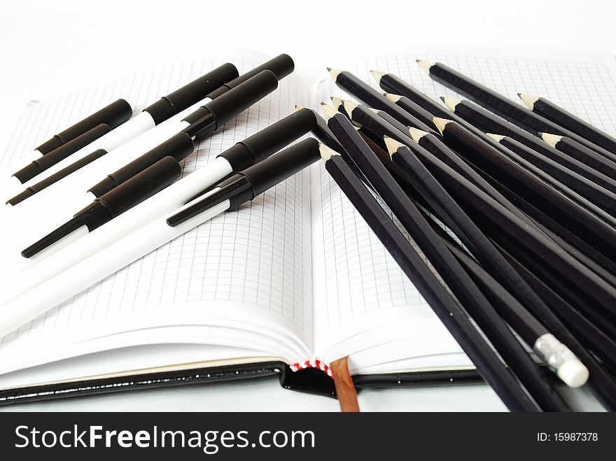 Pens and pencils for note-book with pages in a cage. Pens and pencils for note-book with pages in a cage