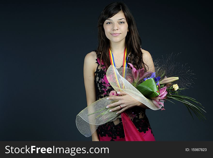 Young woman winning competition and posing with flowers and medal. Young woman winning competition and posing with flowers and medal