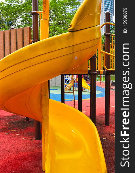 A yellow twisted kiddie slide on the playground. A yellow twisted kiddie slide on the playground