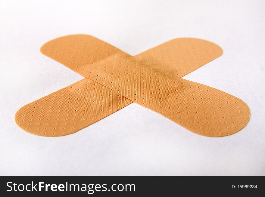 First aid plasters cross at white background