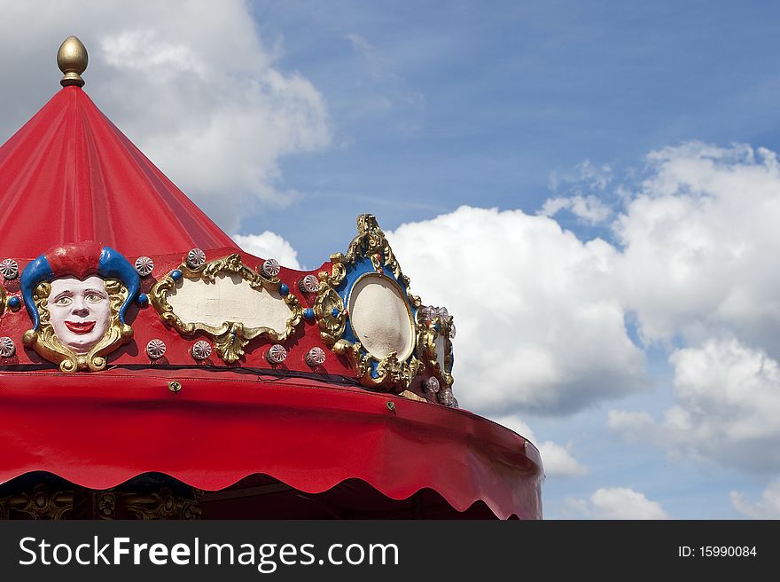 Red Roof carousel with decorations in the blue sky. Red Roof carousel with decorations in the blue sky