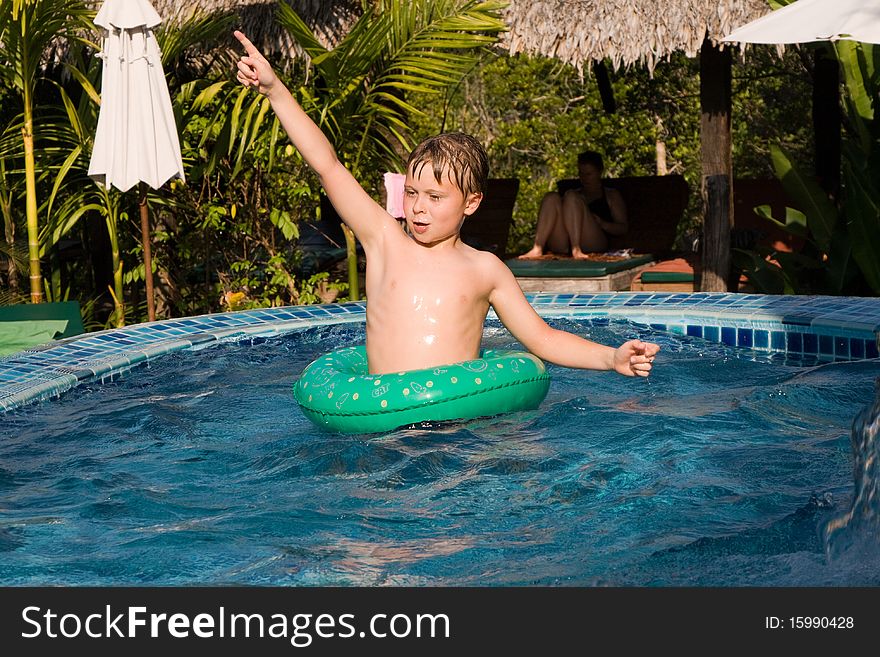 Young Boy In A Floting Tyre Enjoys The Pool