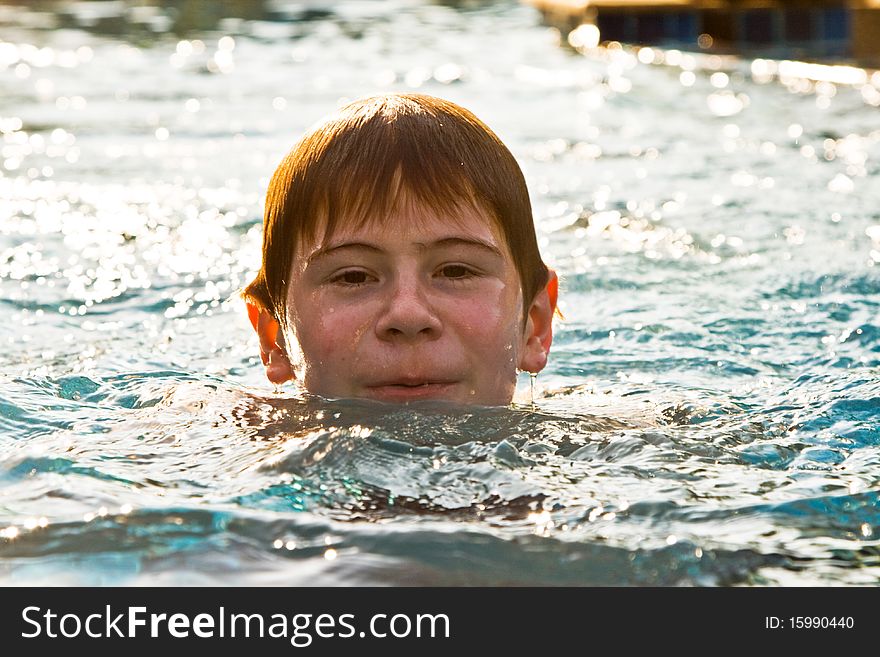 Boy With Red Hair Is Swimming In The Pool