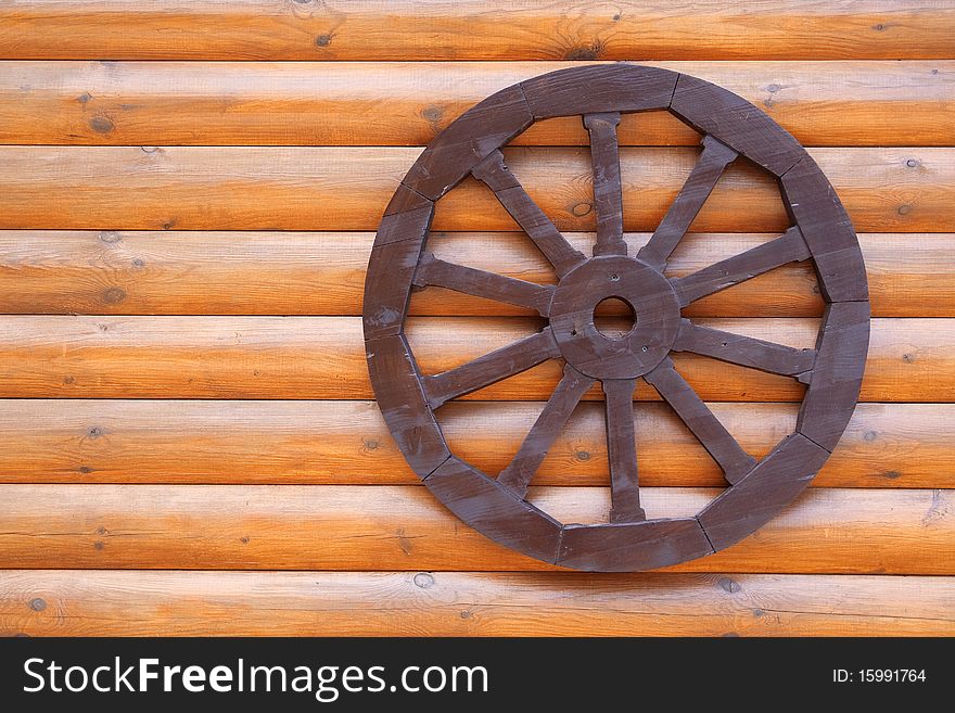 A fragment of wood veneer wall with an attached wheel. Texture, background. A fragment of wood veneer wall with an attached wheel. Texture, background