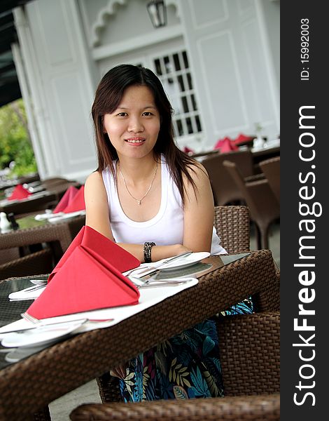 Image of a young Asian lady smiling at restaurant. Image of a young Asian lady smiling at restaurant