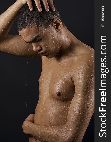 Drops of the water on naked body of a young man on black background. Drops of the water on naked body of a young man on black background.