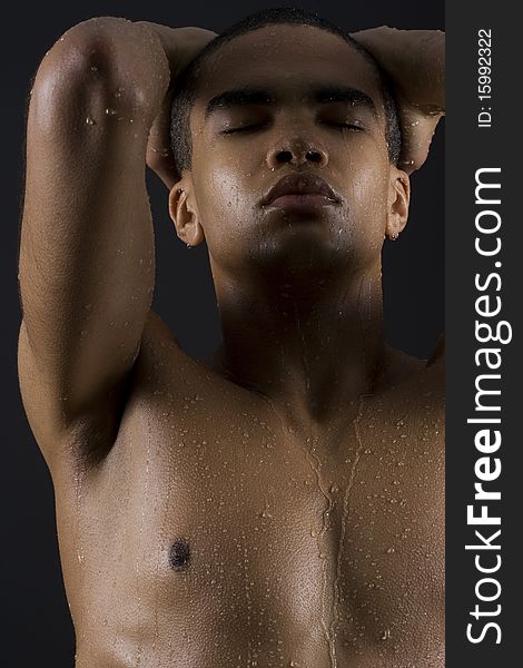 Drops of the water on naked body of a young man on black background. Drops of the water on naked body of a young man on black background.