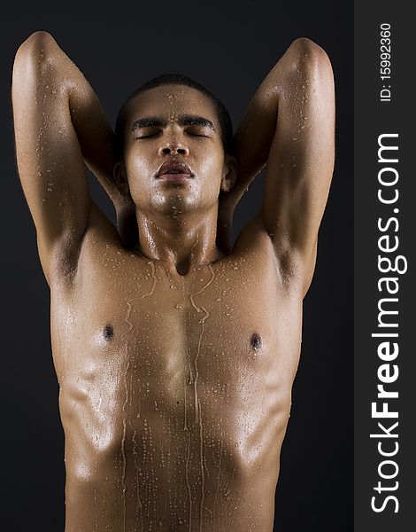 Drops of the water on naked body of a young man on black background. Drops of the water on naked body of a young man on black background.