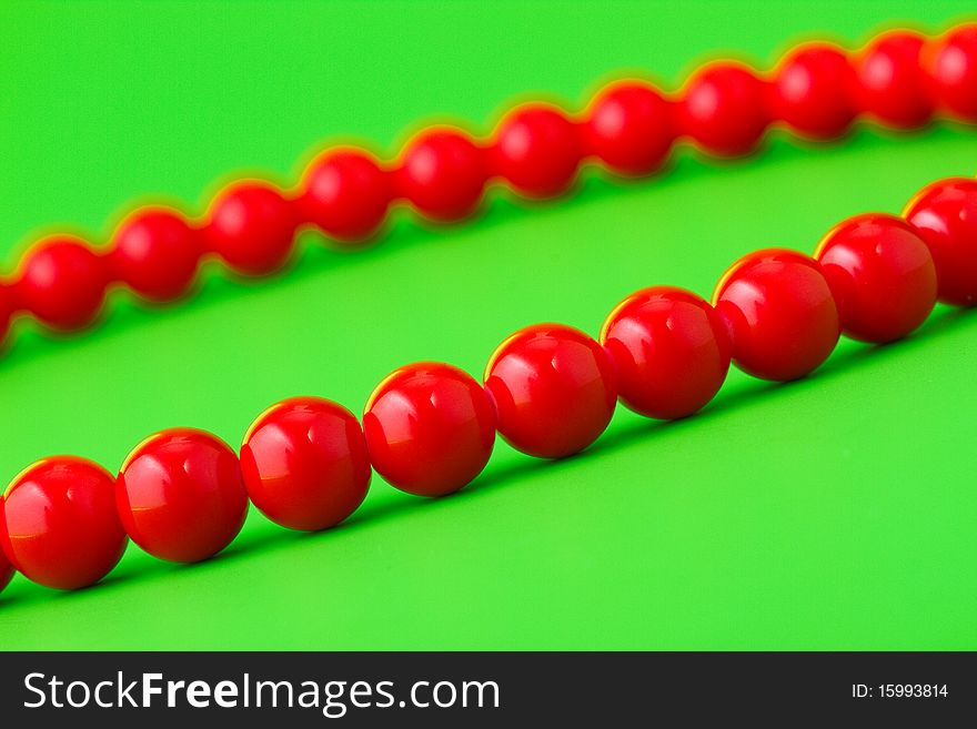 Red womans beads on green background. Red womans beads on green background