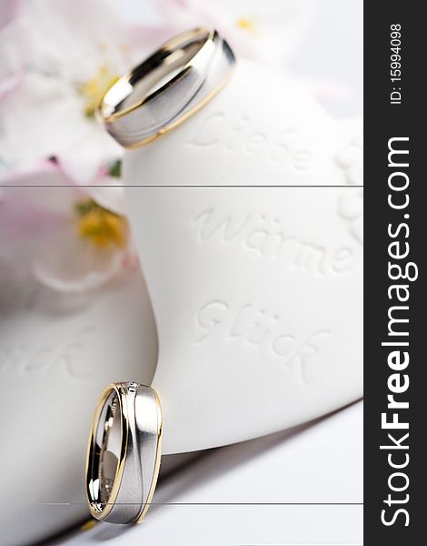 Two wedding rings with flowers in the background