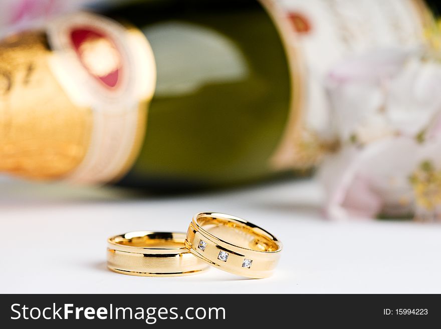 Two wedding rings with a bottle champagner in the back