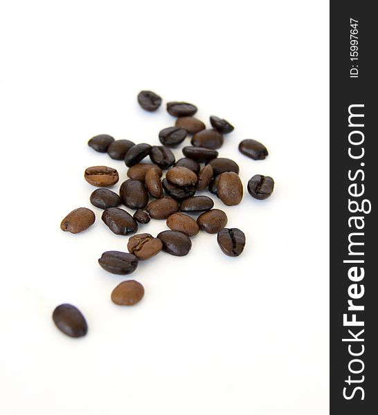 Coffee beans spilled onto a white background