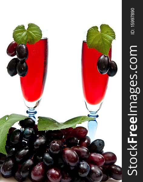 Red wine in glasses with plump grapes. Isolated on white. Red wine in glasses with plump grapes. Isolated on white