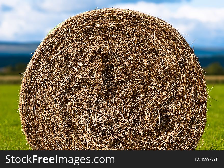 Hay bales on a field with clouds in background. Hay bales on a field with clouds in background