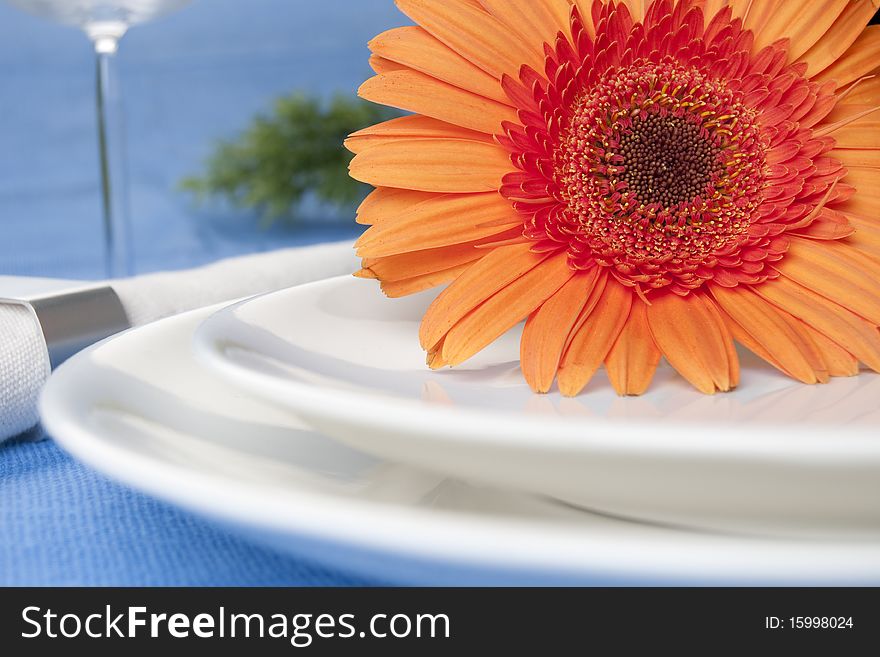 Orange flower and white plates with napkin. Orange flower and white plates with napkin