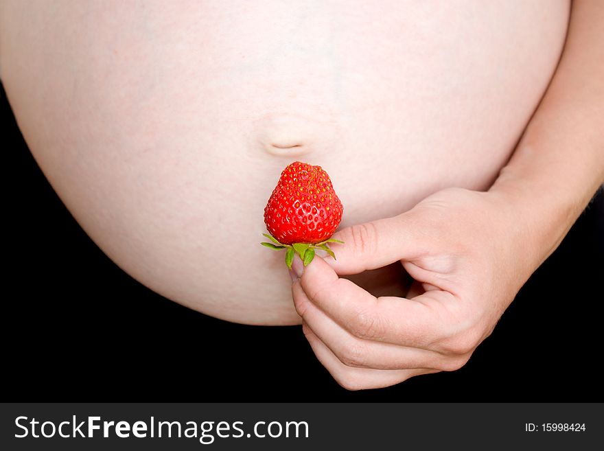 Pregnant women with strawberries in the stomach. Belly and strawberries.