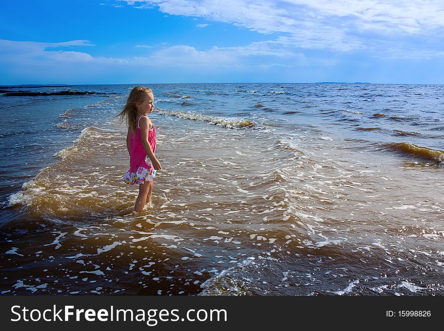 The little girl igret water on the beach. The little girl igret water on the beach.