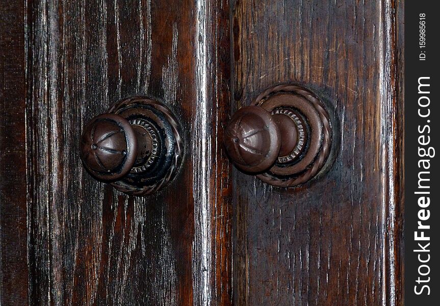 old oak wooden door with worn metal door knob and handle