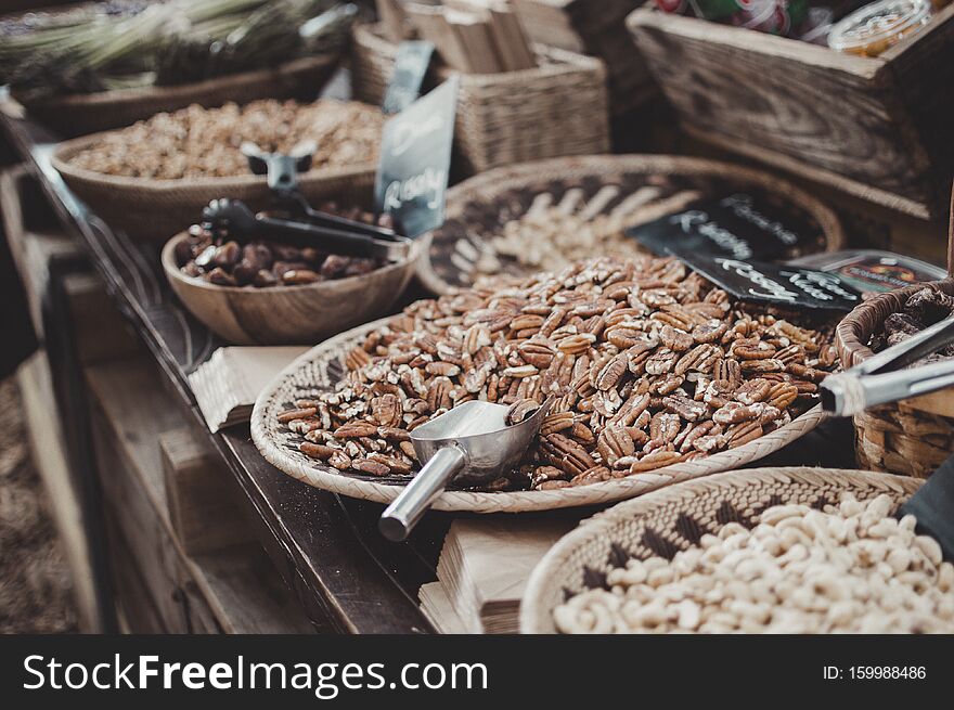 Hazelnuts, dates, groundnuts,  in  a woven basket being sold at the market. Hazelnuts, dates, groundnuts,  in  a woven basket being sold at the market