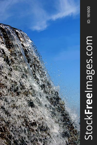 The top of a waterfall against a deep blue sky. The top of a waterfall against a deep blue sky