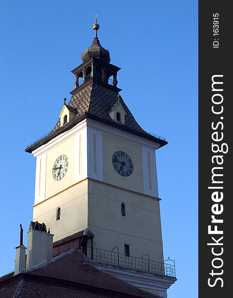 A square clock tower with a blue sky background